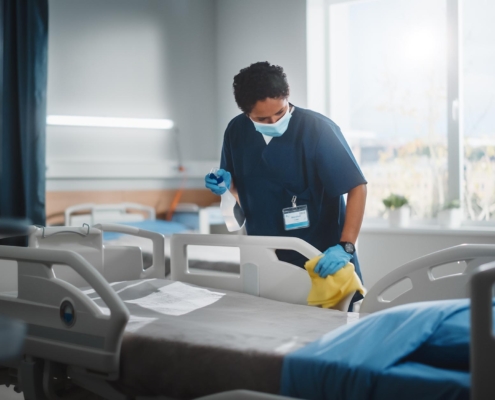 worker cleaning medical bed