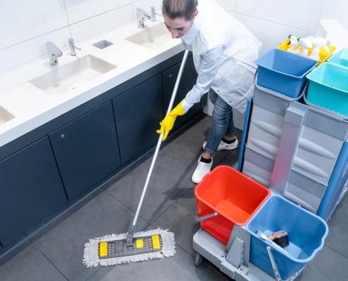 Person mopping floor in school bathroom