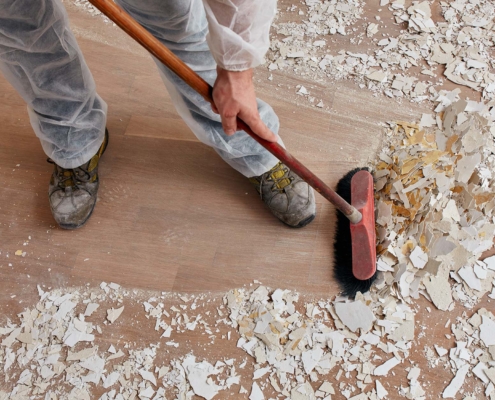 Builder sweeping the floor after renovation